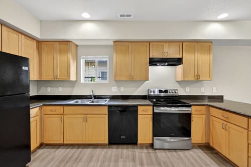 Kitchen with stainless steel appliances and granite countertops at Glisan Townhomes